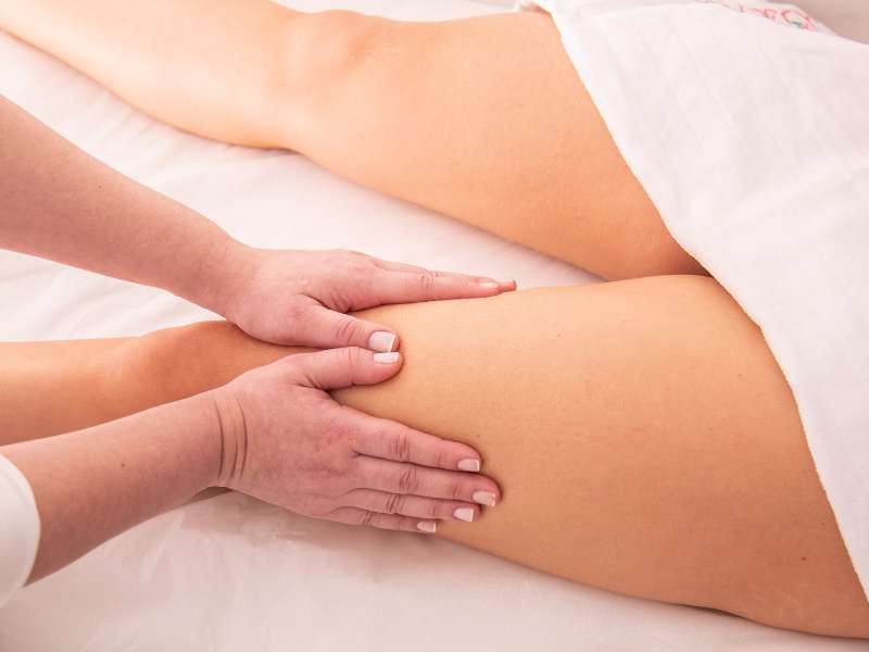 Mulher recebendo massagem de drenagem linfática na coxa